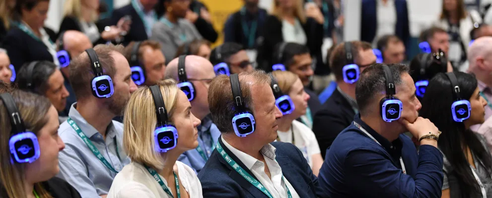Asistentes de congreso escuchando con auriculares multicanal