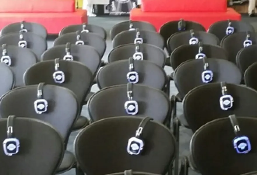 Auditorio con auriculares colocados en cada butaca