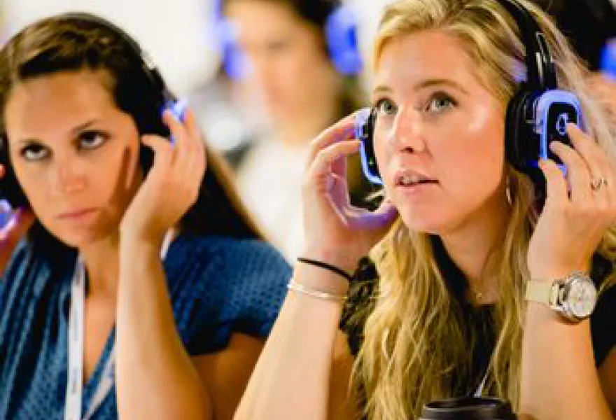 Asistentes ajustando sus auriculares de traducción simultánea