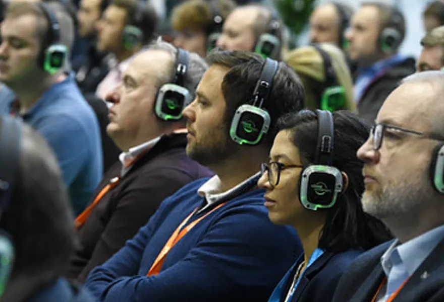 Directivos siguiendo una ponencia con auriculares inalámbricos