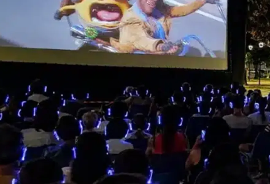 Cine al aire libre con público usando auriculares inalámbricos