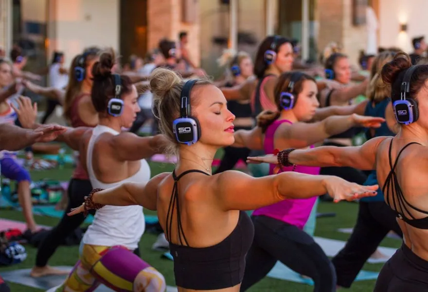 Clase colectiva de fitness con auriculares inalámbricos