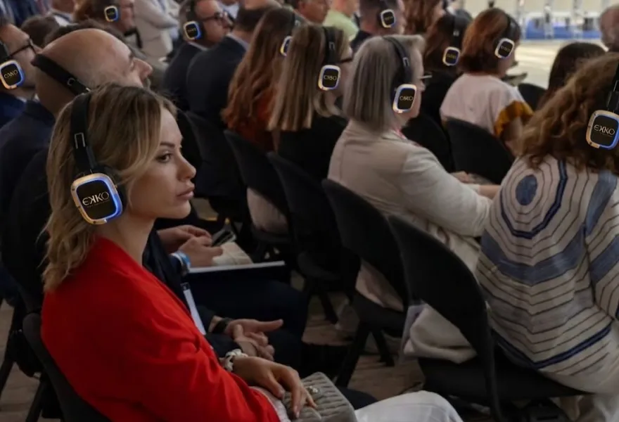 Público de conferencia siguiendo la ponencia con auriculares