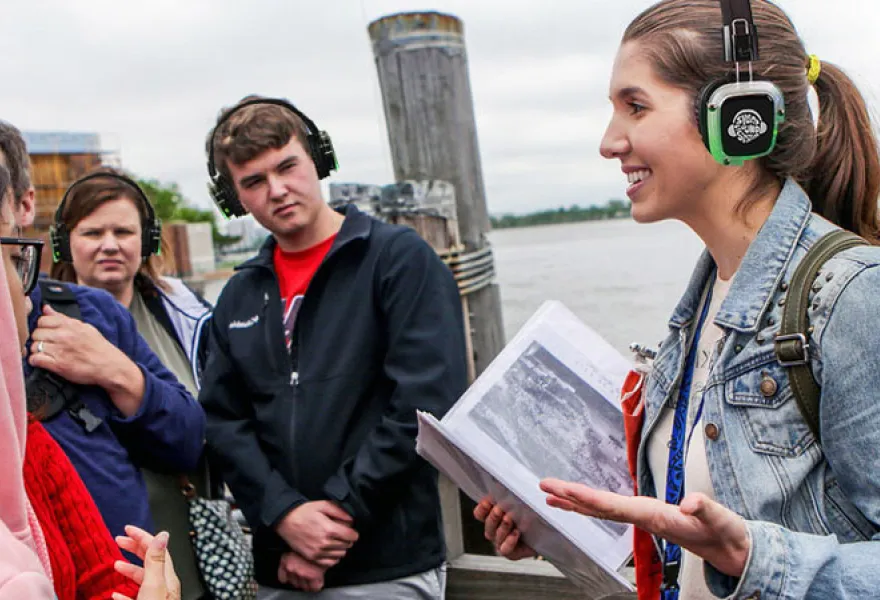 Guía turística explicando a un grupo con auriculares inalámbricos