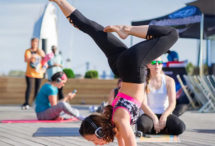 Práctica de yoga en terraza con auriculares silenciosos