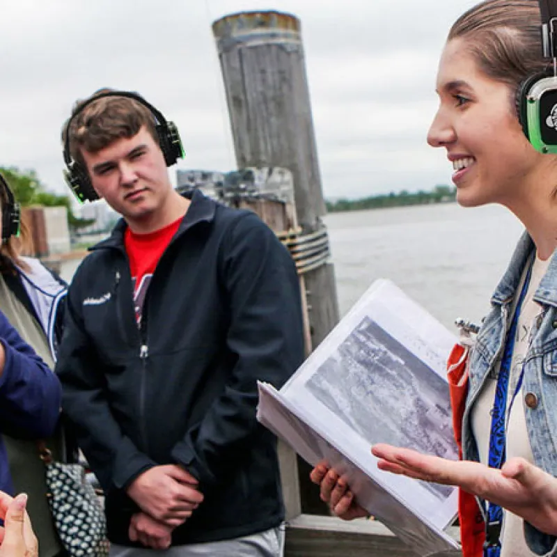 Guía turística explicando a un grupo con auriculares inalámbricos