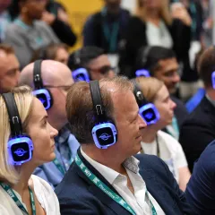 Asistentes de congreso escuchando con auriculares multicanal