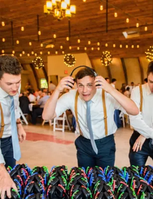 Invitados de boda de noche con auriculares iluminados