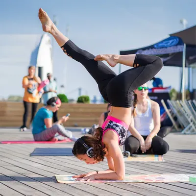 Práctica de yoga en terraza con auriculares silenciosos