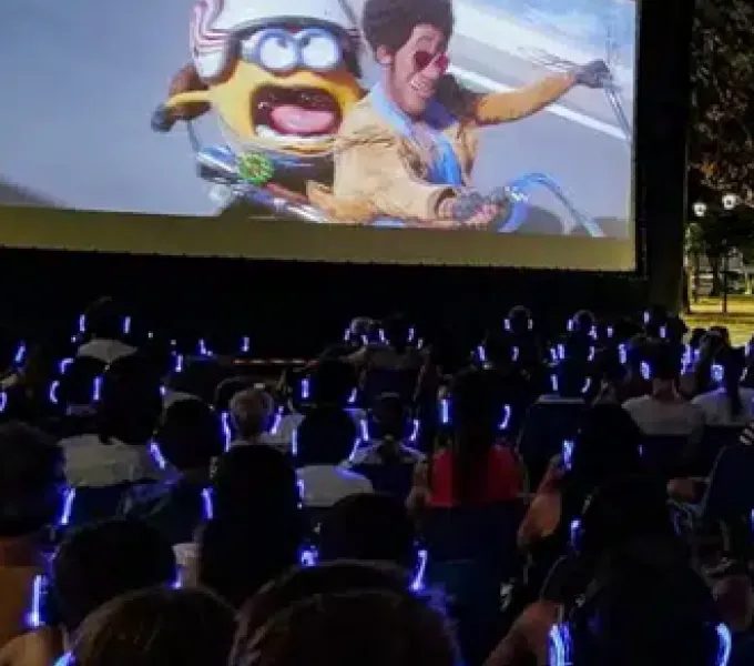 Cine al aire libre con público usando auriculares inalámbricos